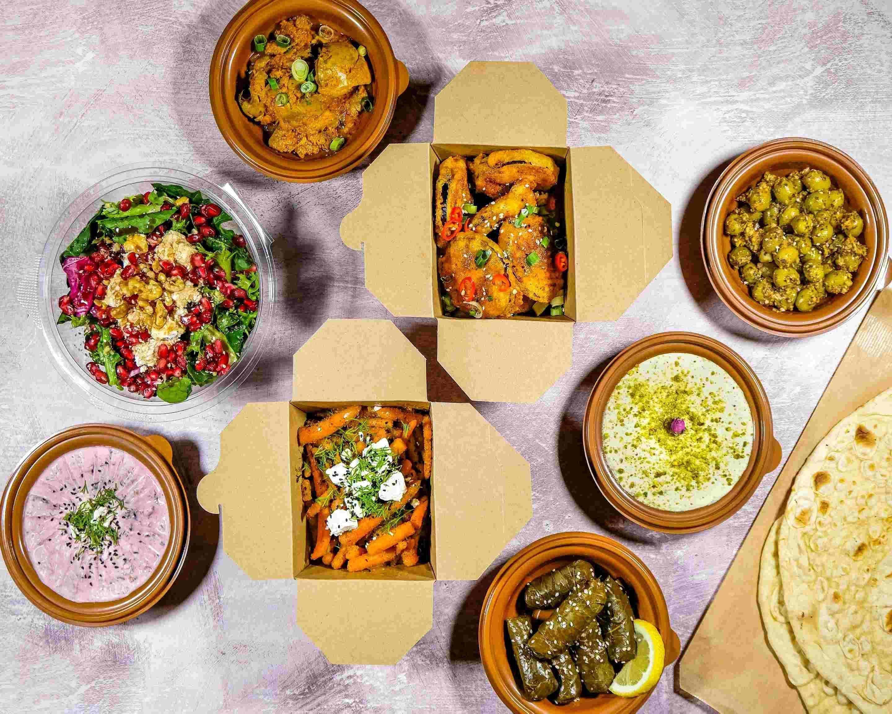 Saffron dishes styled around open takeaway boxes