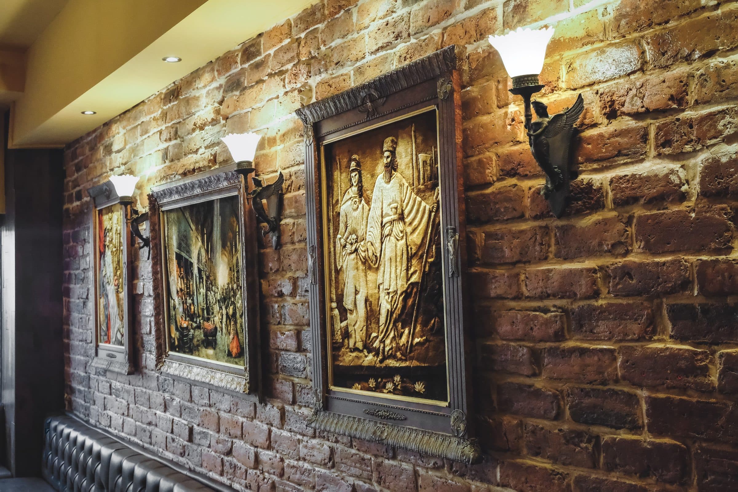 Inside Saffron — exposed brick, lamplight and framed Persian artwork above the banquettes